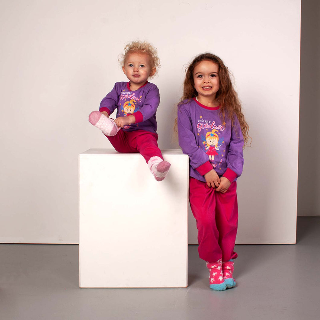 2 young girls wearing purple and pink fairy pyjamas